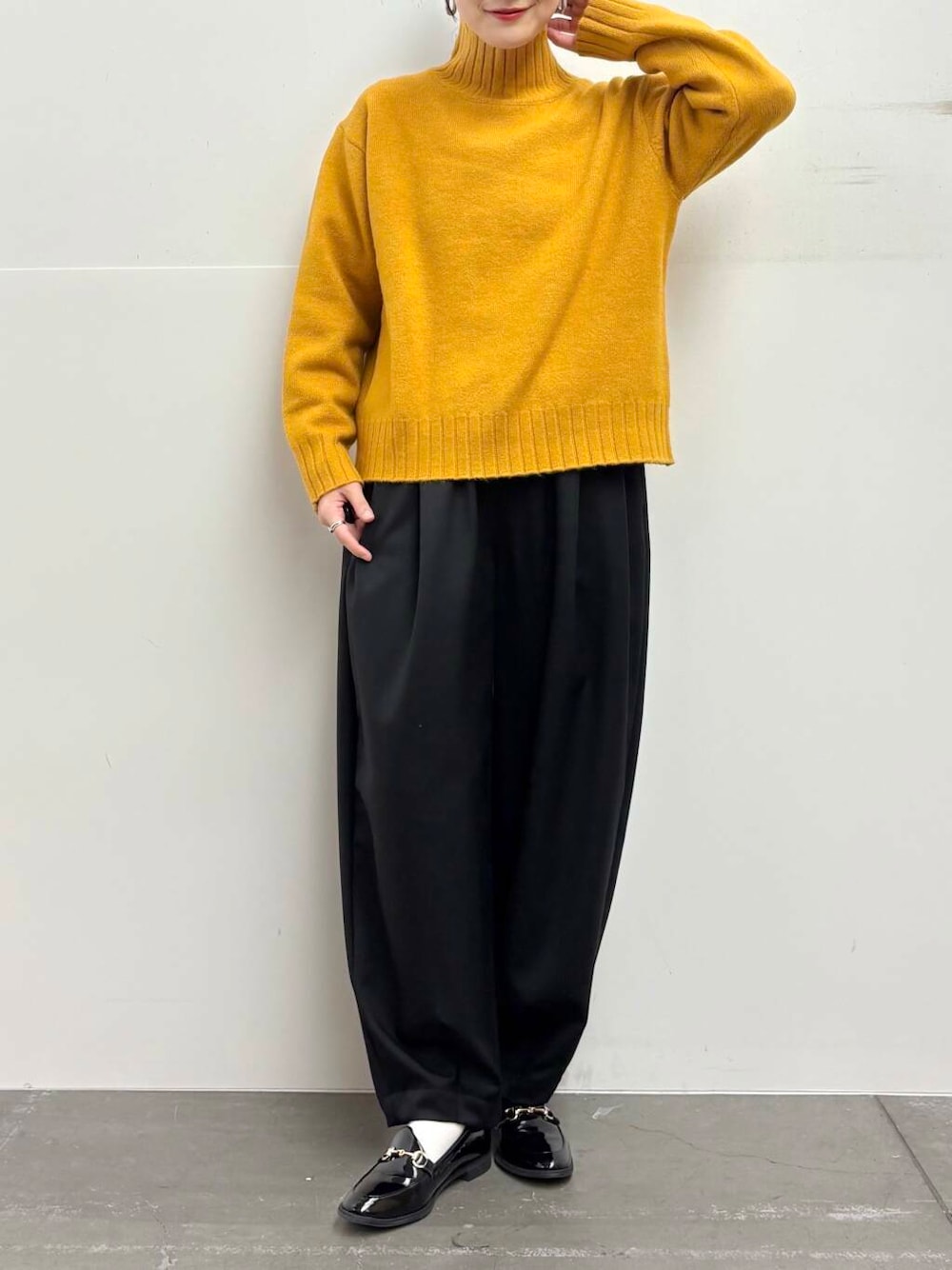 ブラック系のローファー、イエロー系のニット/セーター、ブラック系のその他パンツを着用したレディースの冬コーディネートの7枚目の写真