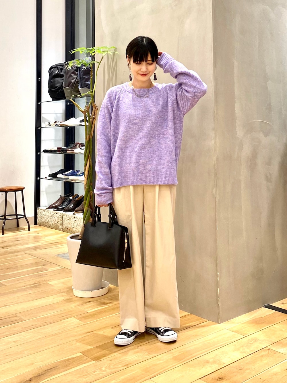 パープル系のニット/セーター、ホワイト系のその他パンツ、ブラック系のトートバッグを着用したレディースの冬コーディネートの2枚目の写真