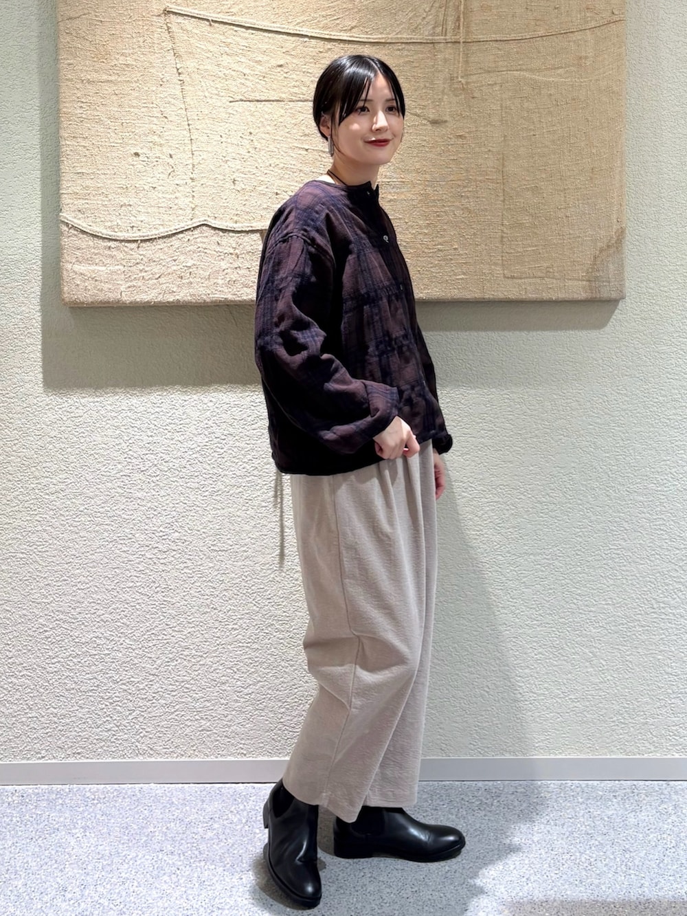 ブラウン系のカーディガン/ボレロ、グレー系のその他パンツ、ブラック系のブーツを着用したレディースの秋コーディネートの2枚目の写真