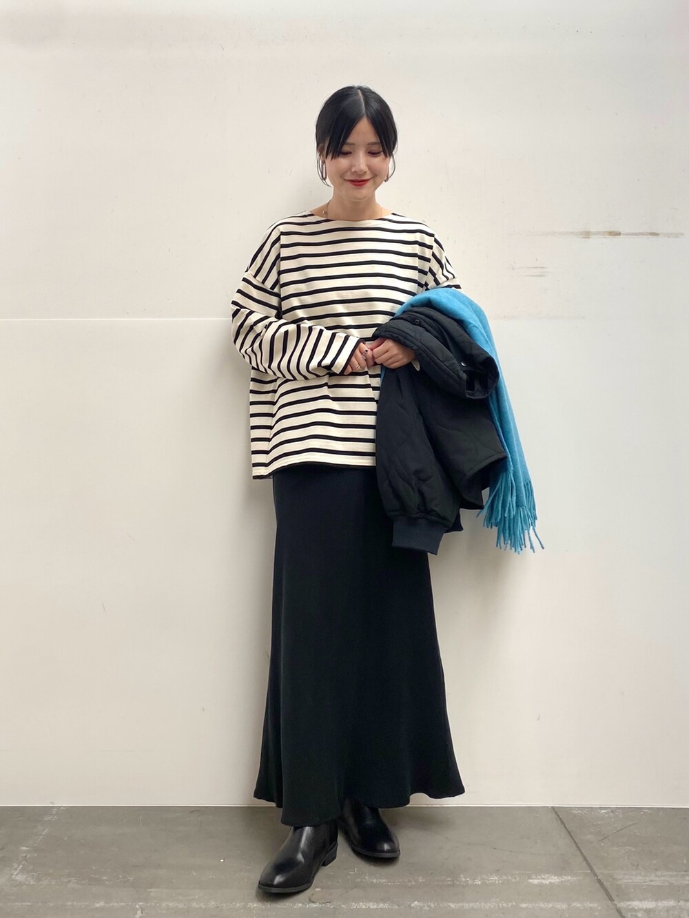 ブラック系のブルゾン、ホワイト系のTシャツ/カットソー、ブラック系のスカートを着用したレディースの秋コーディネートの4枚目の写真