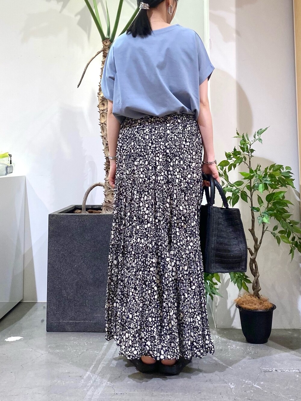 ブルー系のTシャツ/カットソー、ブラック系のスカート、ブラック系のハンドバッグを着用したレディースの春コーディネートの5枚目の写真