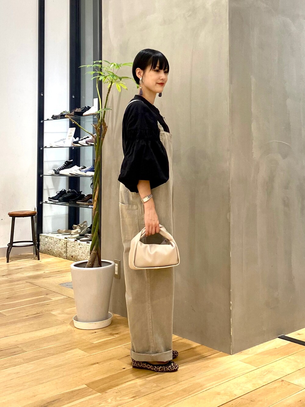 ブラック系のシャツ/ブラウス、グレー系のサロペット/オーバーオール、ホワイト系のショルダーバッグを着用したレディースの秋コーディネートの3枚目の写真