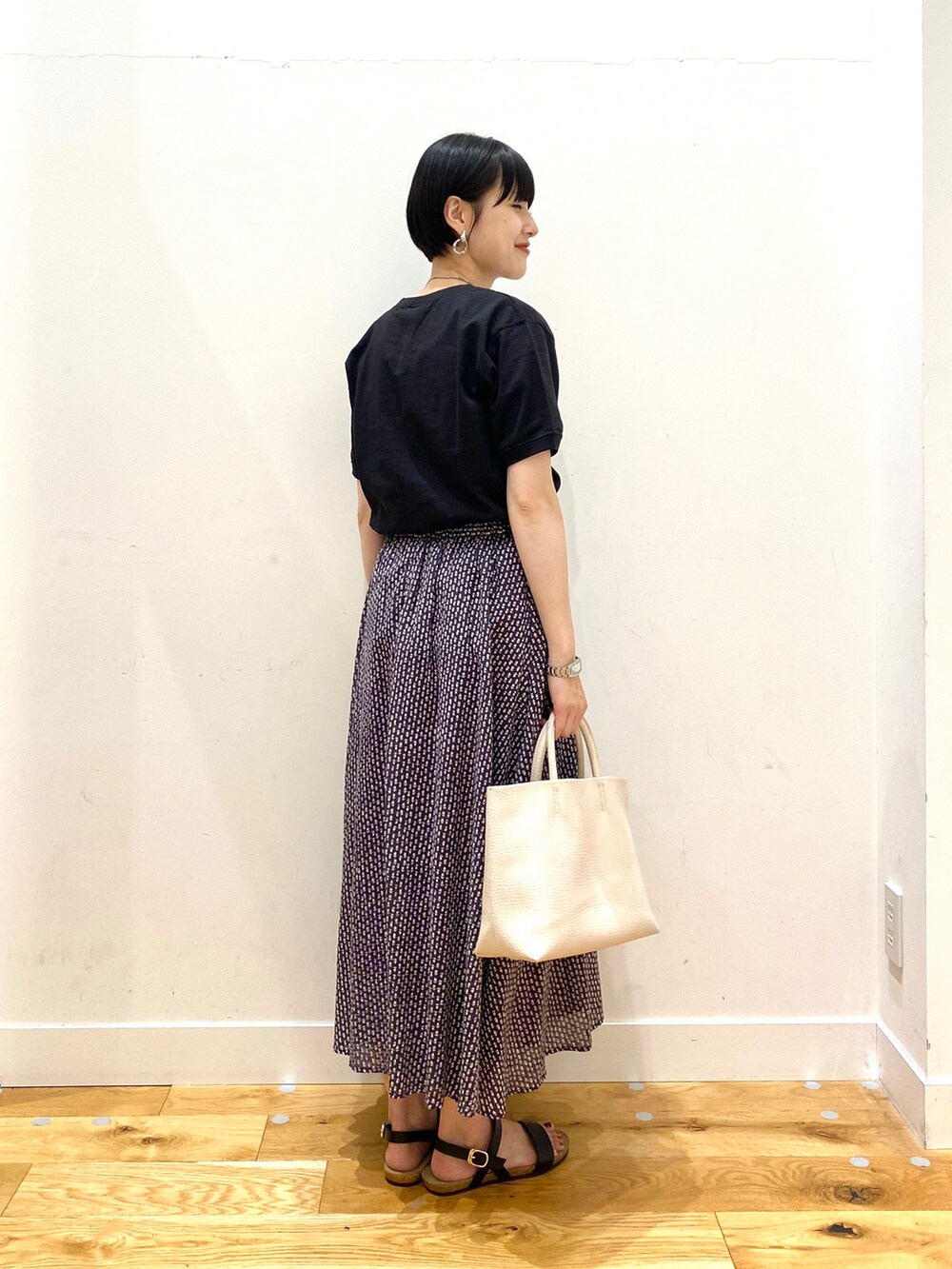 ブラック系のTシャツ/カットソー、グレー系のスカート、ホワイト系のトートバッグを着用したレディースの夏コーディネートの3枚目の写真