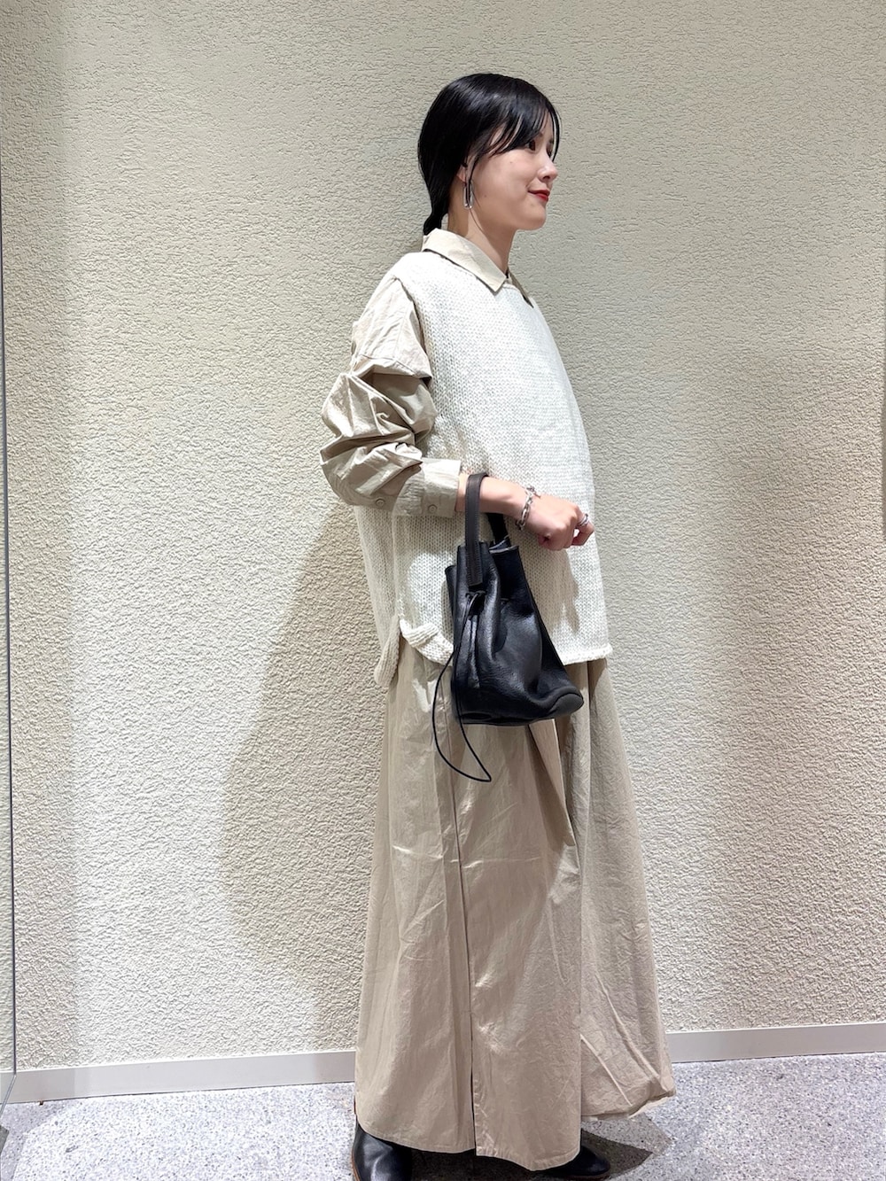 ベージュ系のワンピース、ホワイト系のニット/セーター、ブラック系のバレエシューズを着用したレディースの秋コーディネートの2枚目の写真