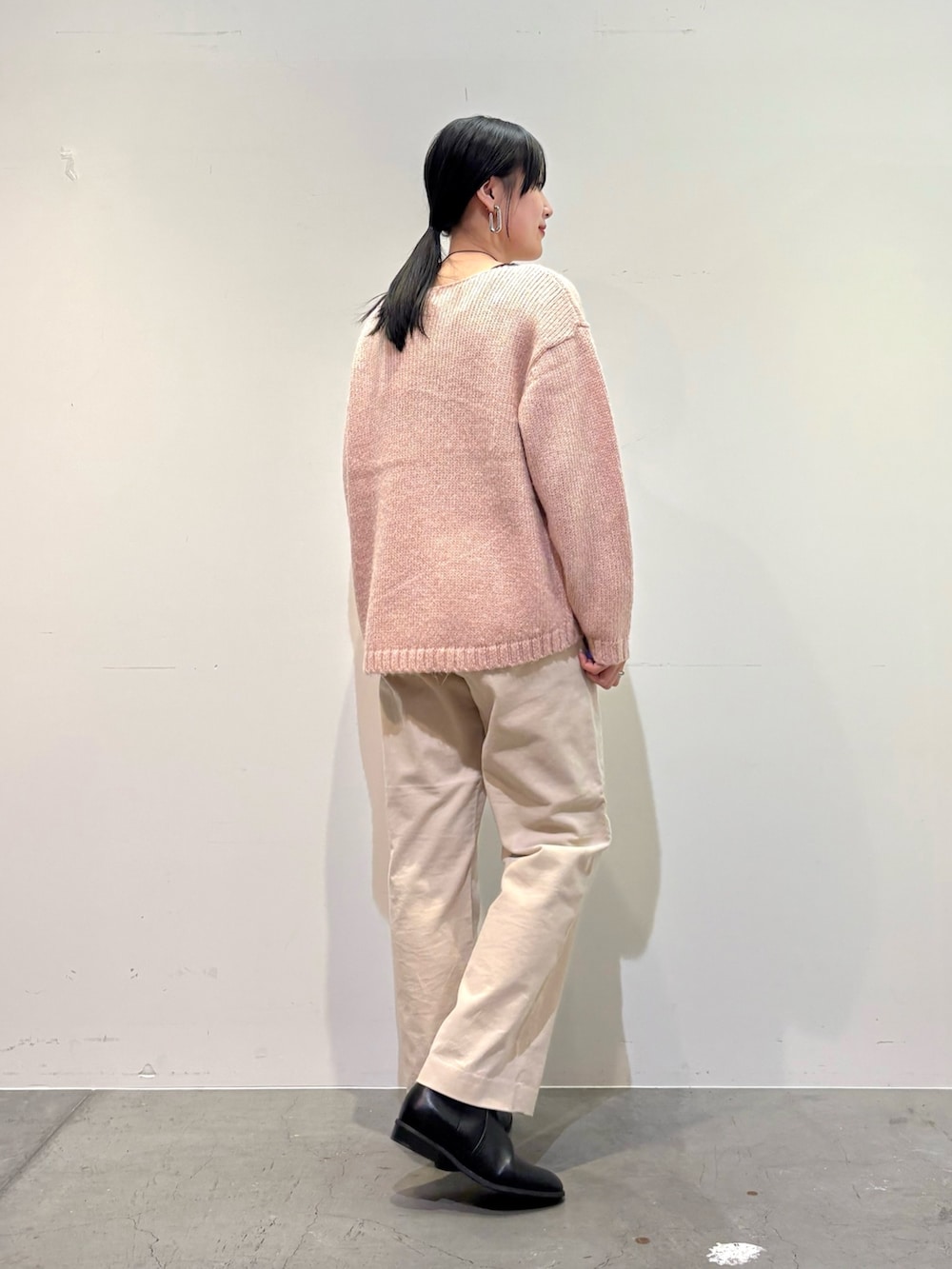 ピンク系のニット/セーター、ホワイト系のその他パンツ、ブラック系のブーツを着用したレディースの冬コーディネートの4枚目の写真
