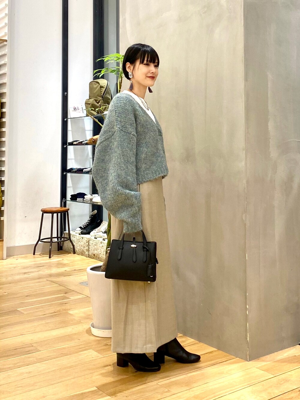 ブルー系のカーディガン/ボレロ、ホワイト系のTシャツ/カットソー、ベージュ系のスカートを着用したレディースの秋コーディネートの3枚目の写真