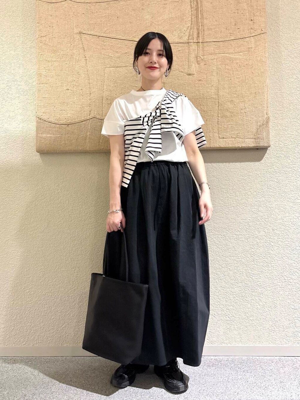 ブラック系のTシャツ/カットソーを着用したレディースの春コーディネートの2枚目の写真