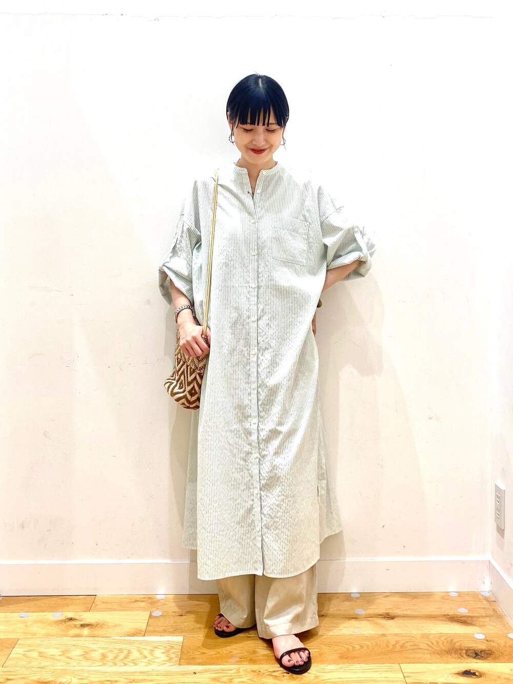 グリーン系のワンピース、ベージュ系のその他パンツ、ブラウン系のショルダーバッグを着用したレディースの夏コーディネートの2枚目の写真