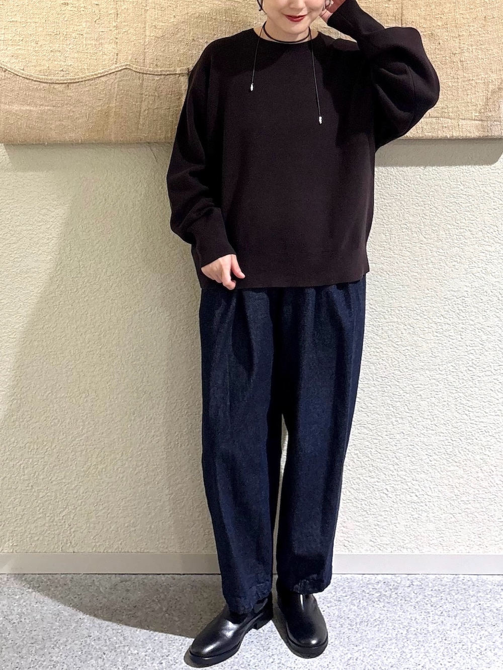 ブラウン系のニット/セーター、ブラウン系のニット/セーター、ブルー系のデニムパンツを着用したレディースの秋コーディネートの4枚目の写真