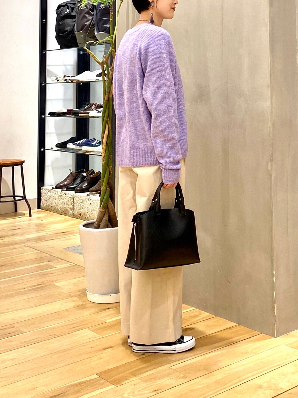 パープル系のニット/セーター、ホワイト系のその他パンツ、ブラック系のトートバッグを着用したレディースの冬コーディネートの5枚目の写真