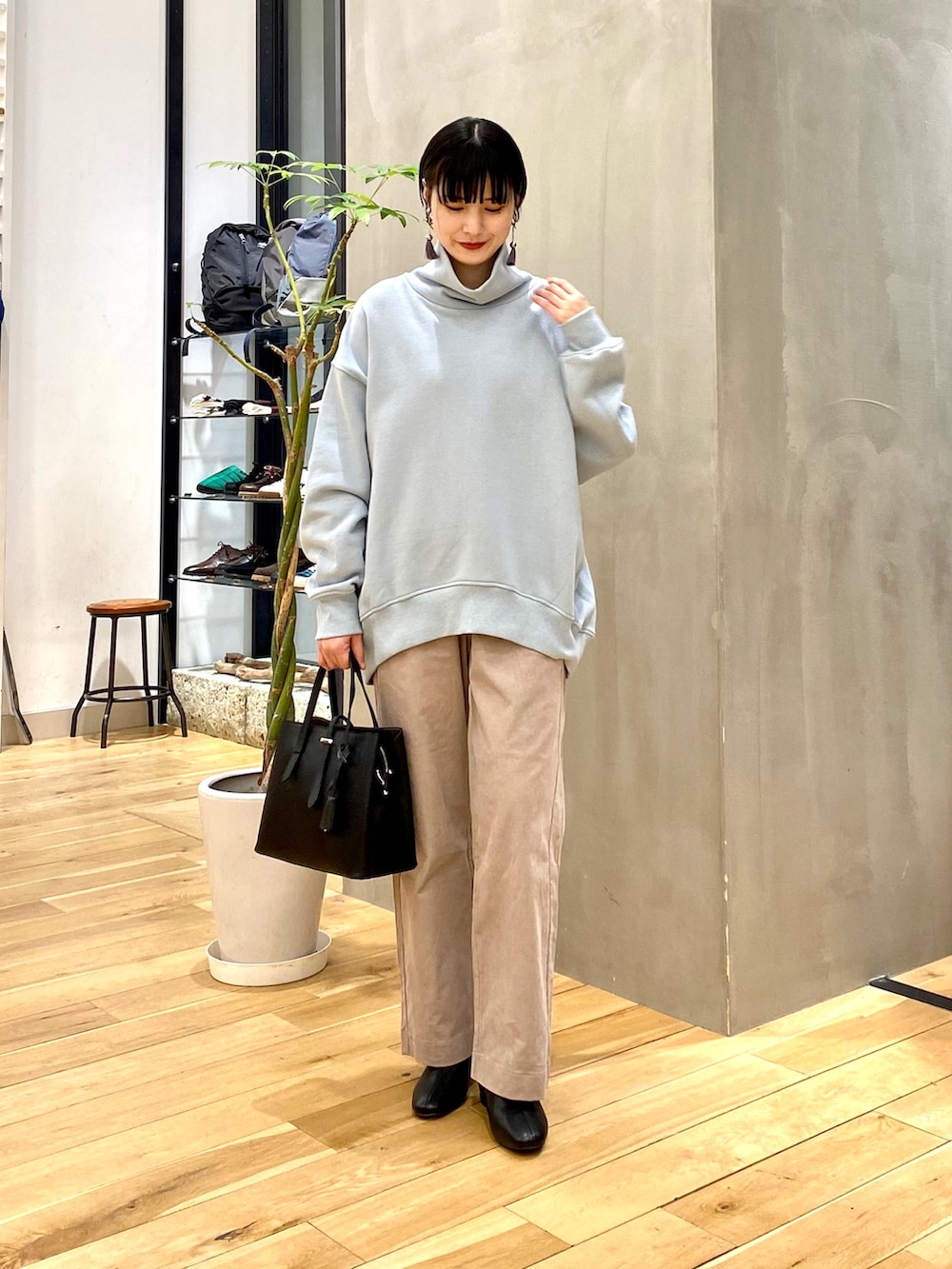 ブルー系のスウェット、ベージュ系のその他パンツ、ブラック系のトートバッグを着用したレディースの冬コーディネートの2枚目の写真