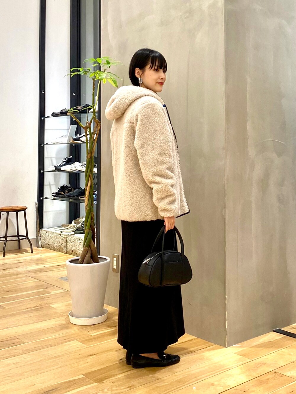 ホワイト系のTシャツ/カットソー、ブラック系のスカート、ブラック系のショルダーバッグを着用したレディースの秋コーディネートの2枚目の写真