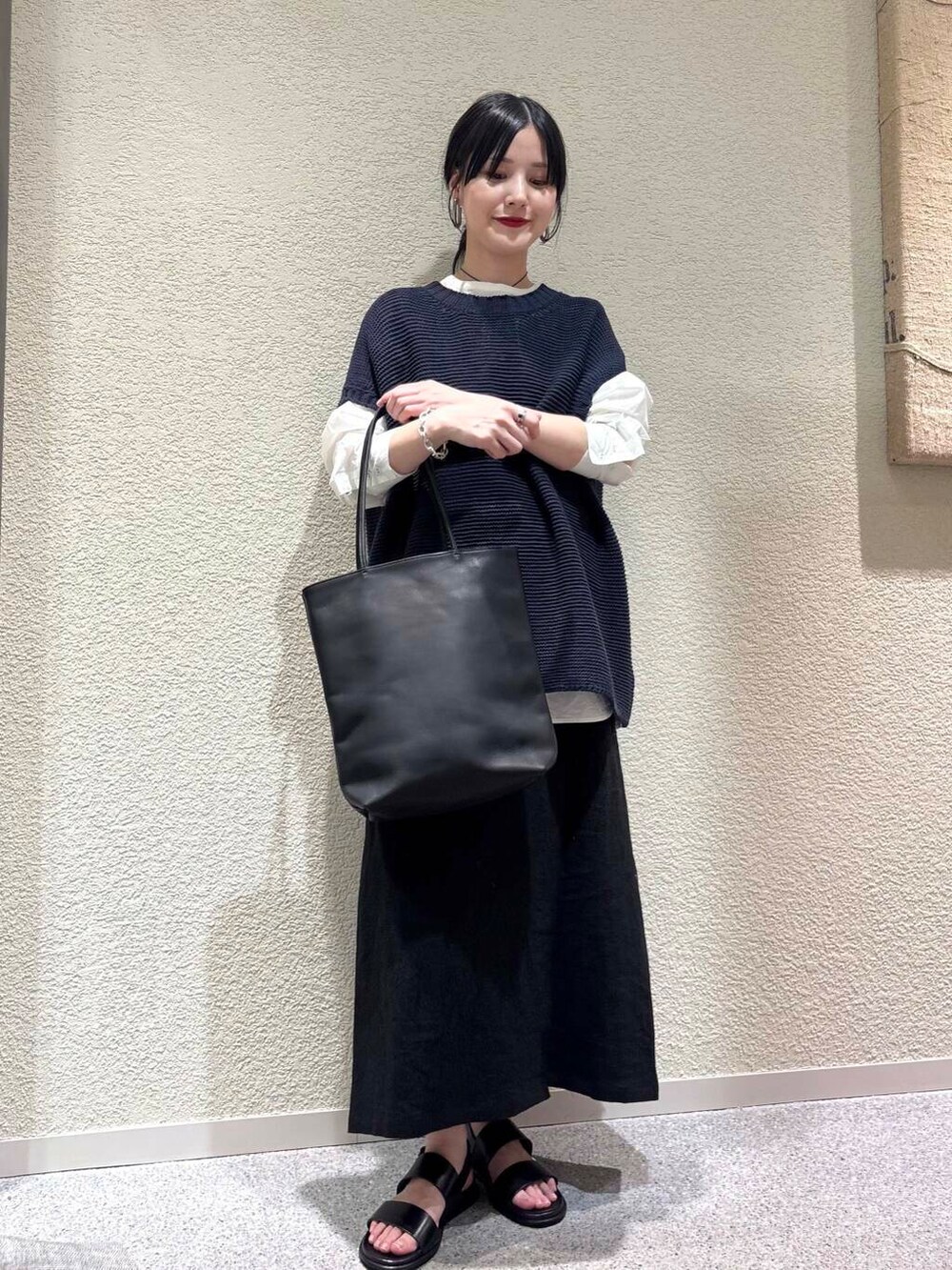 ホワイト系のシャツ/ブラウス、ブルー系のベスト、ブラック系のスカートを着用したレディースの春コーディネートの6枚目の写真