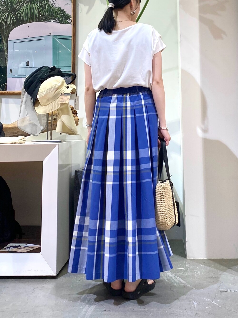 ホワイト系のTシャツ/カットソー、ブルー系のスカート、ベージュ系のトートバッグを着用したレディースの夏コーディネートの5枚目の写真