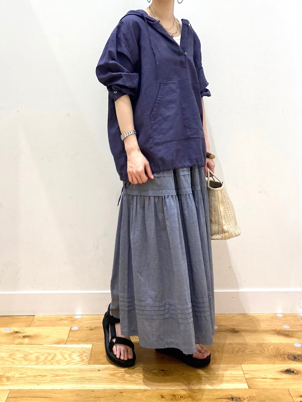 ブルー系のパーカー、ホワイト系のタンクトップ、グレー系のスカートを着用したレディースの春コーディネートの5枚目の写真