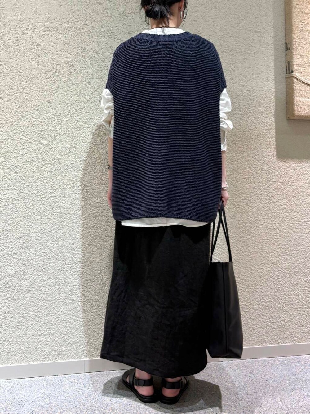 ホワイト系のシャツ/ブラウス、ブルー系のベスト、ブラック系のスカートを着用したレディースの春コーディネートの5枚目の写真