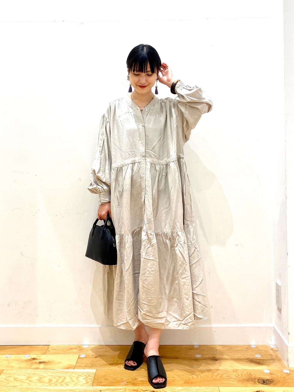 グレー系のワンピース、ブラック系のショルダーバッグ、ブラック系のサンダルを着用したレディースの夏コーディネートの2枚目の写真