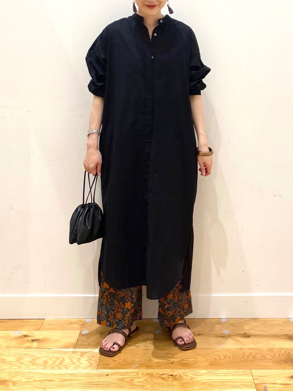 ブラック系のワンピース、オレンジ系のその他パンツ、ブラック系のショルダーバッグを着用したレディースの春コーディネートの4枚目の写真