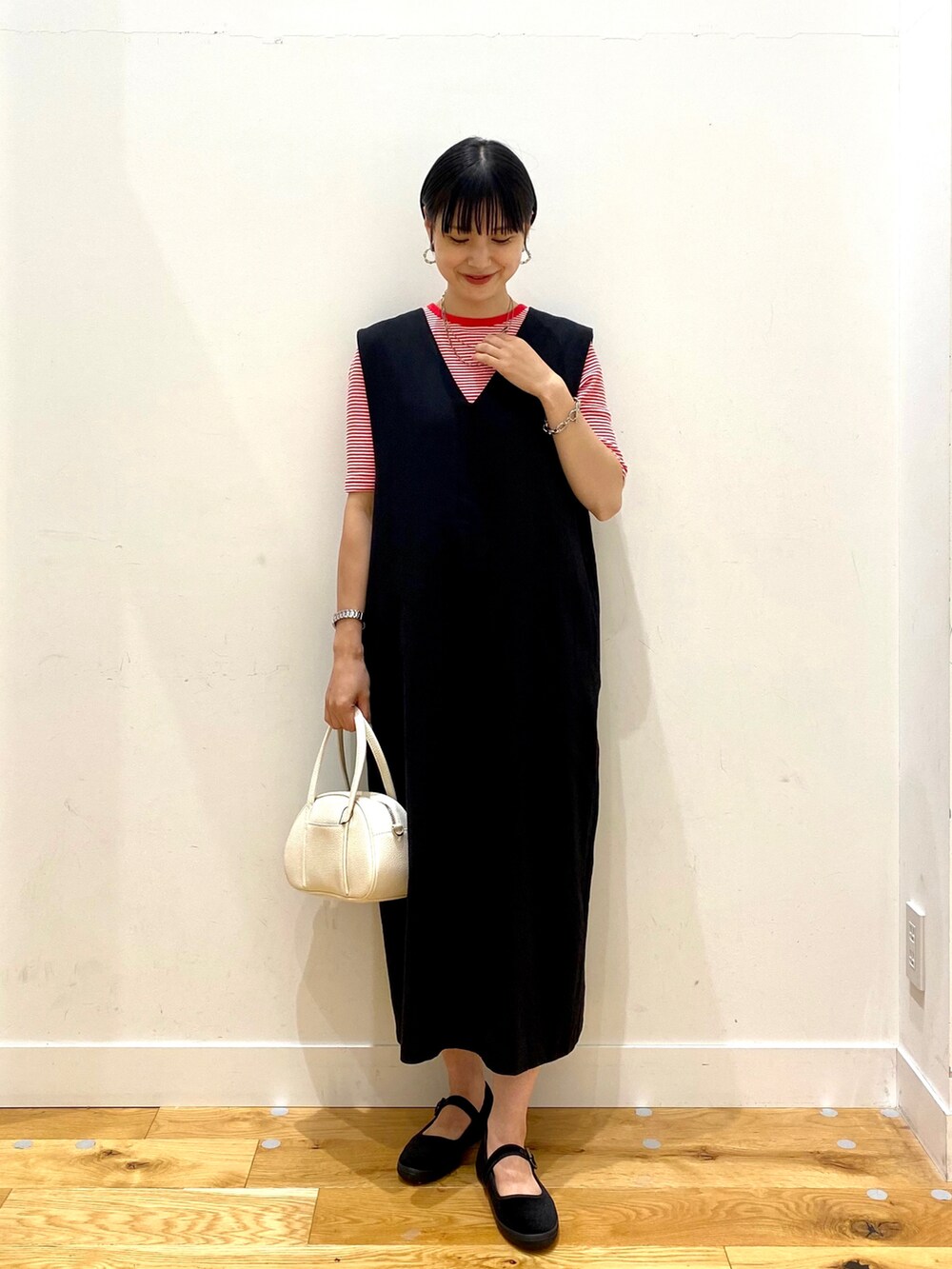 レッド系のTシャツ/カットソー、ブラック系のワンピース、ホワイト系のショルダーバッグを着用したレディースの夏コーディネートの2枚目の写真