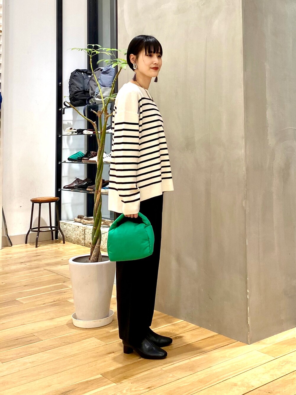 ブラック系のブルゾン、ホワイト系のニット/セーター、ブラック系のその他パンツを着用したレディースの冬コーディネートの4枚目の写真