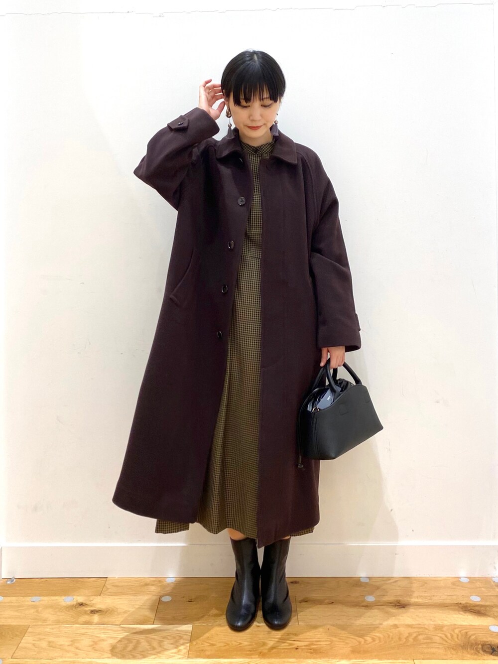 ブラウン系のステンカラーコート、その他のワンピース、ブラック系のショルダーバッグを着用したレディースの秋コーディネートの2枚目の写真
