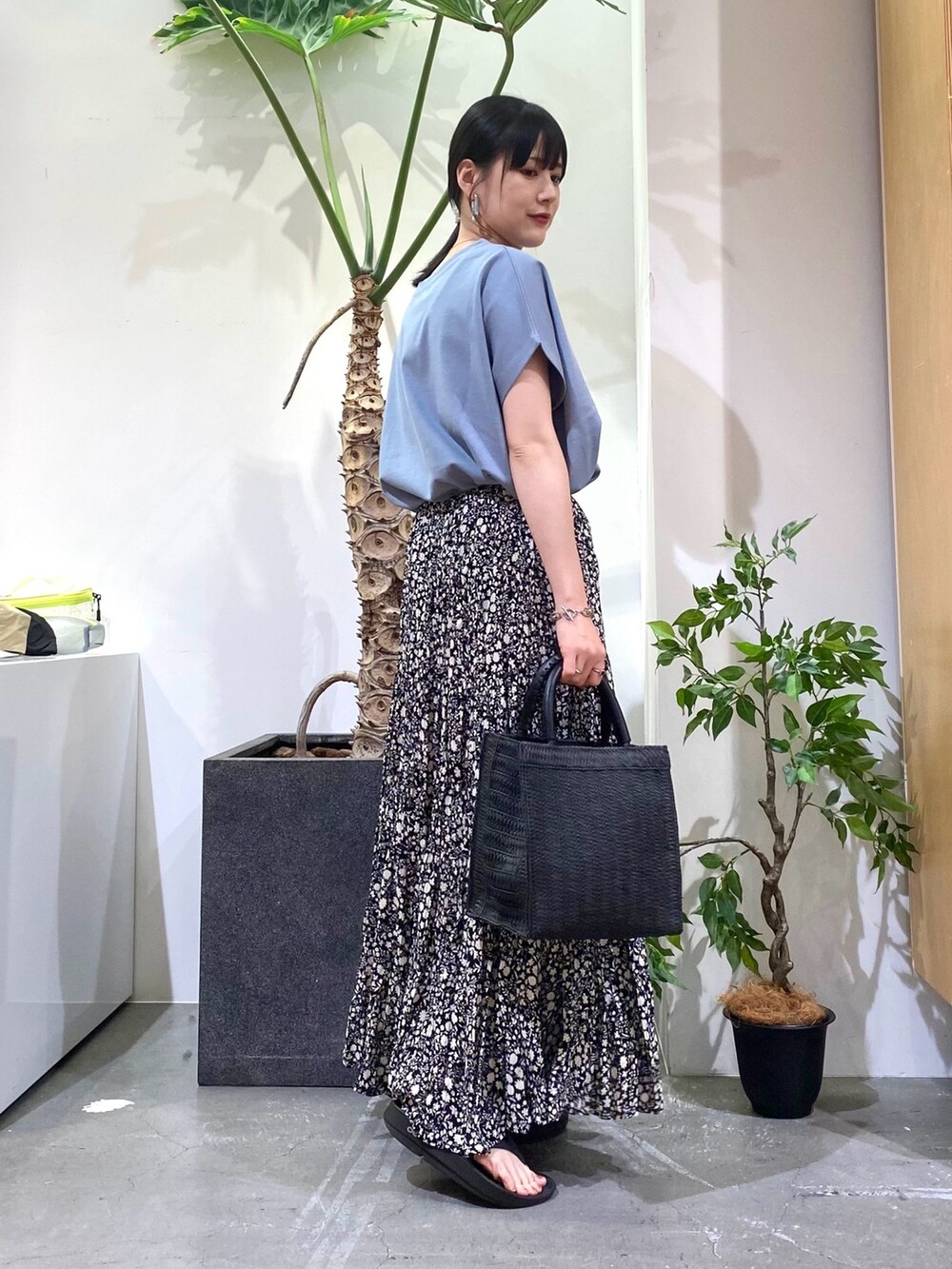 ブルー系のTシャツ/カットソー、ブラック系のスカート、ブラック系のハンドバッグを着用したレディースの春コーディネートの3枚目の写真