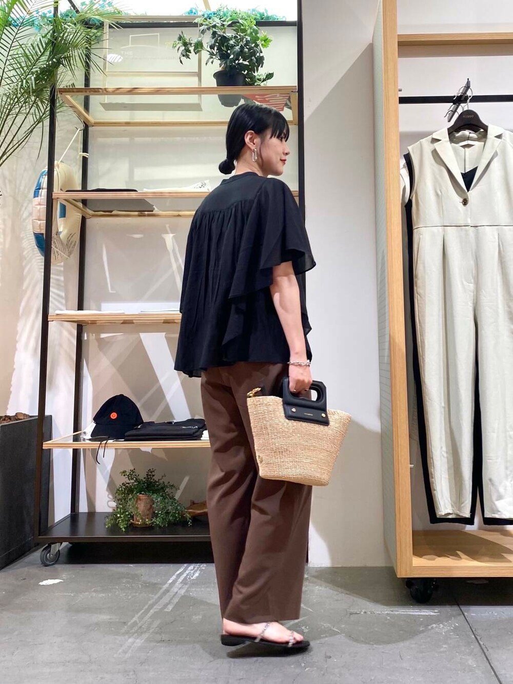 ベージュ系のハンドバッグ、ブラック系のサンダル、ブラック系のシャツ/ブラウスを着用したレディースの夏コーディネートの4枚目の写真