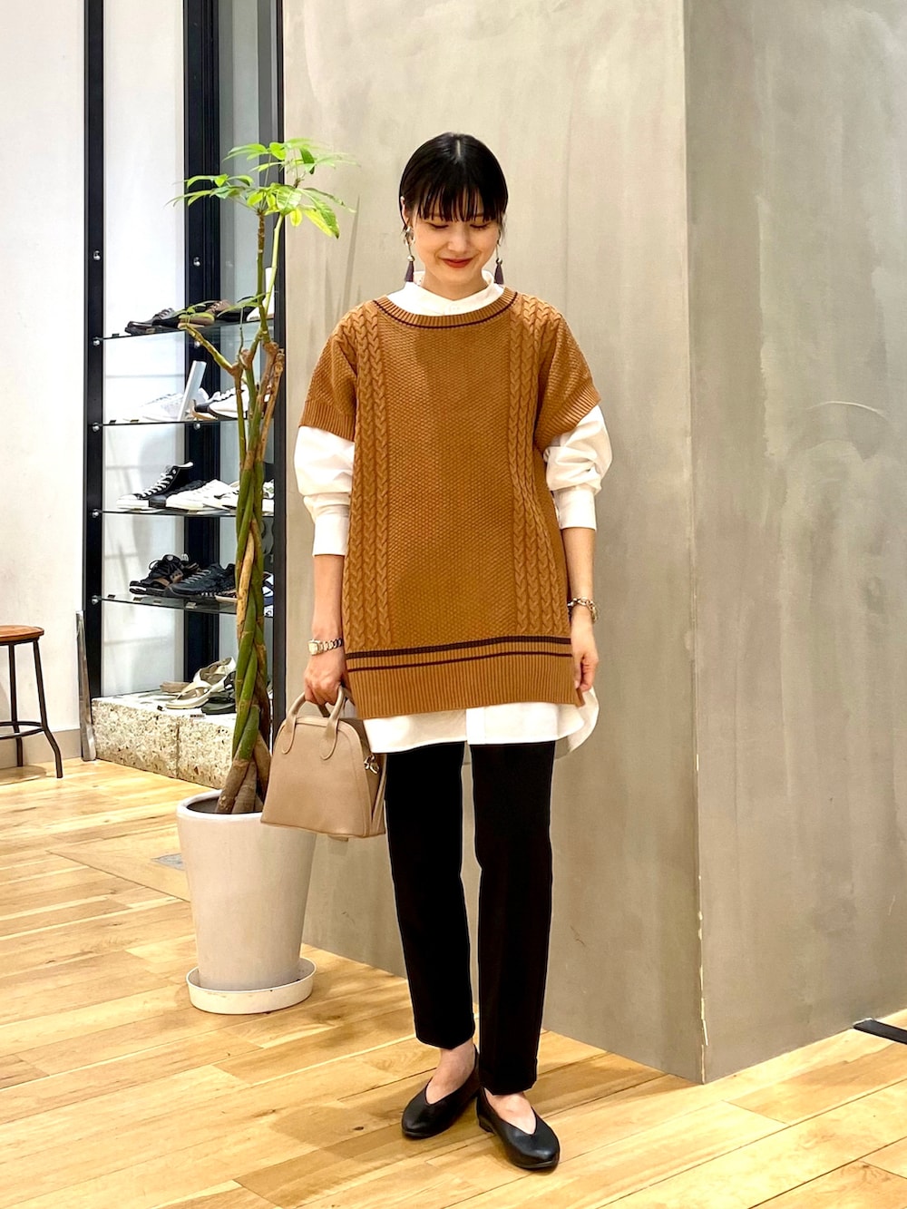 ホワイト系のシャツ/ブラウス、イエロー系のニット/セーター、ブラック系のその他パンツを着用したレディースの秋コーディネートの2枚目の写真