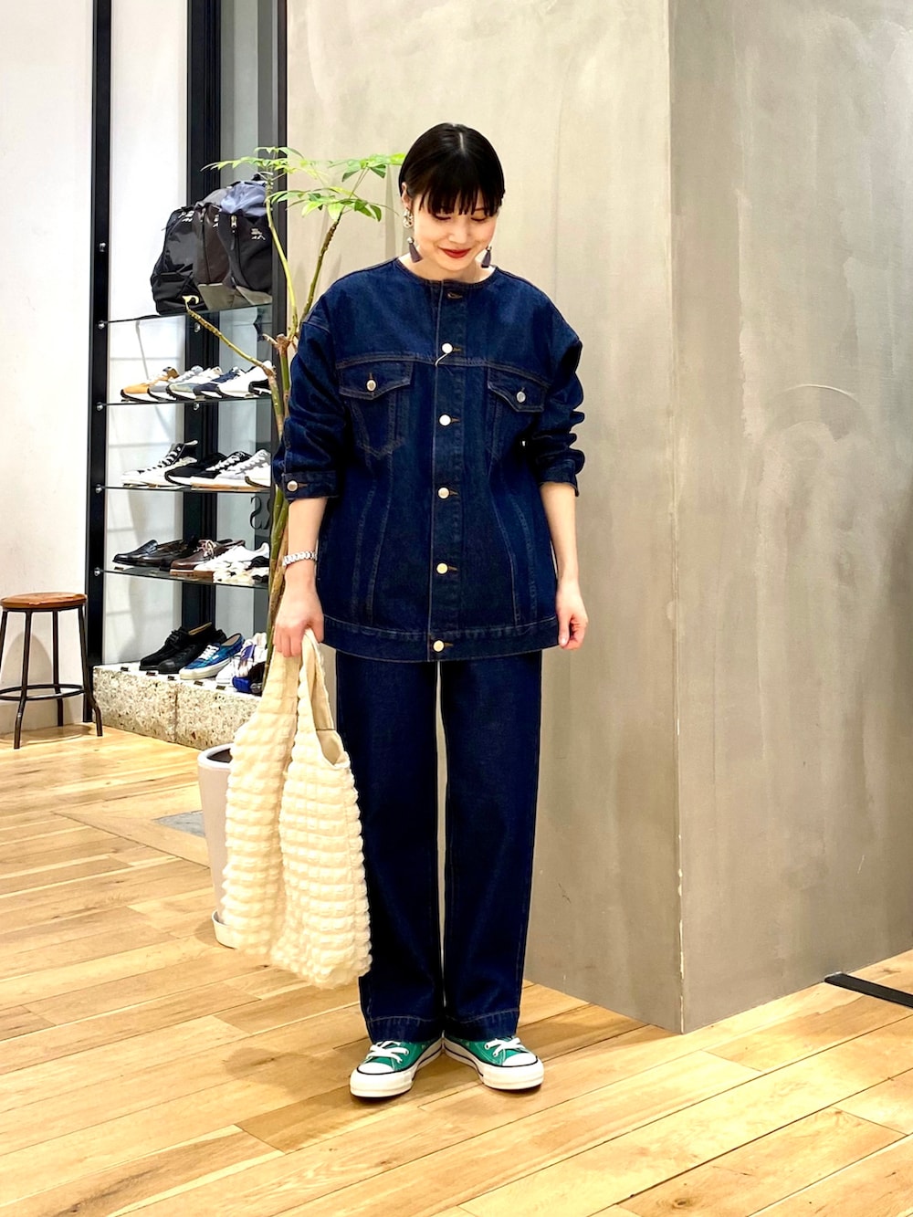 ブルー系のデニムジャケット、ブルー系のデニムパンツ、ホワイト系のトートバッグを着用したレディースの冬コーディネートの2枚目の写真