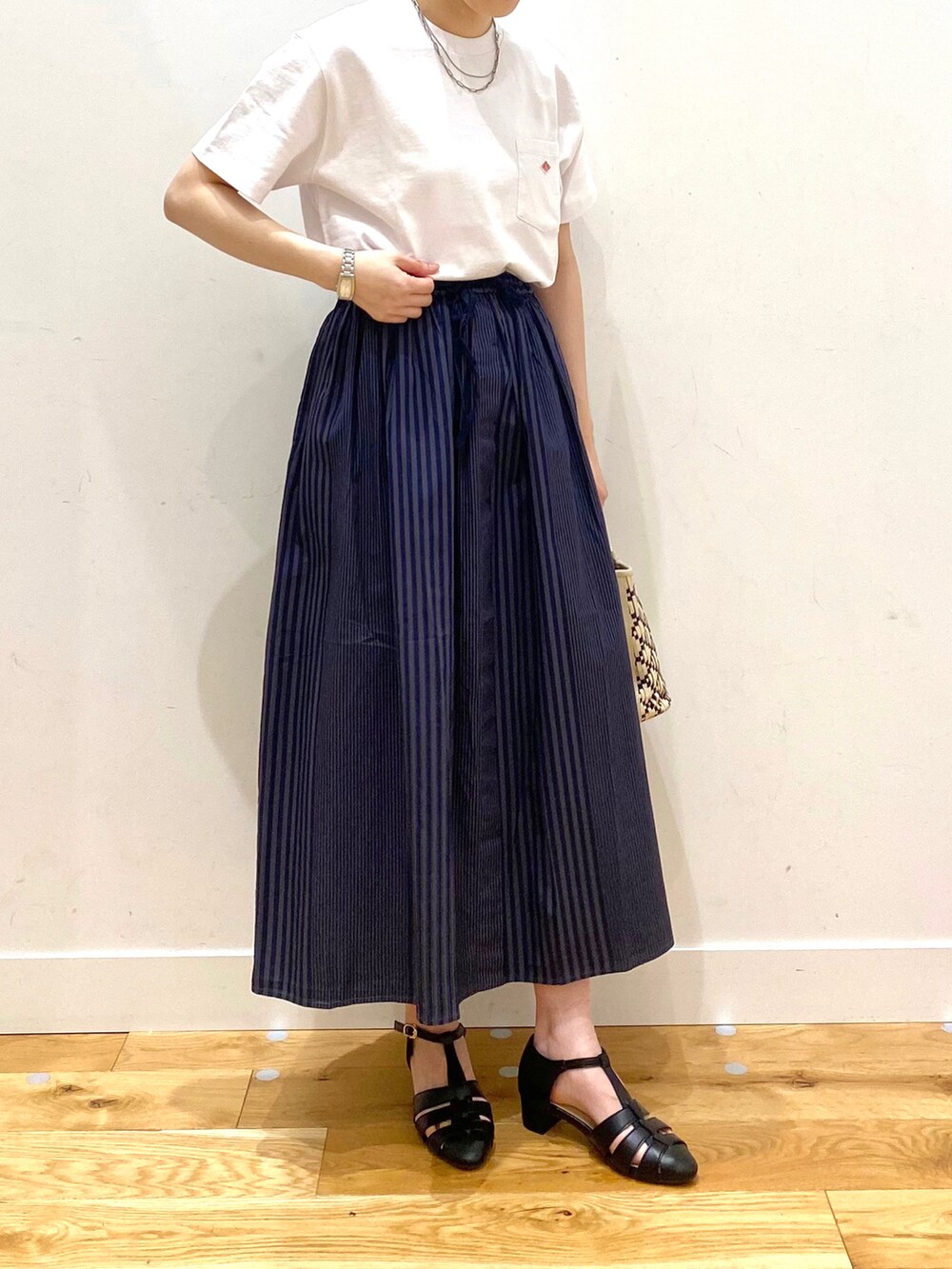 グレー系のスカート、ブラック系のサンダル、ホワイト系のその他を着用したレディースの春コーディネートの4枚目の写真