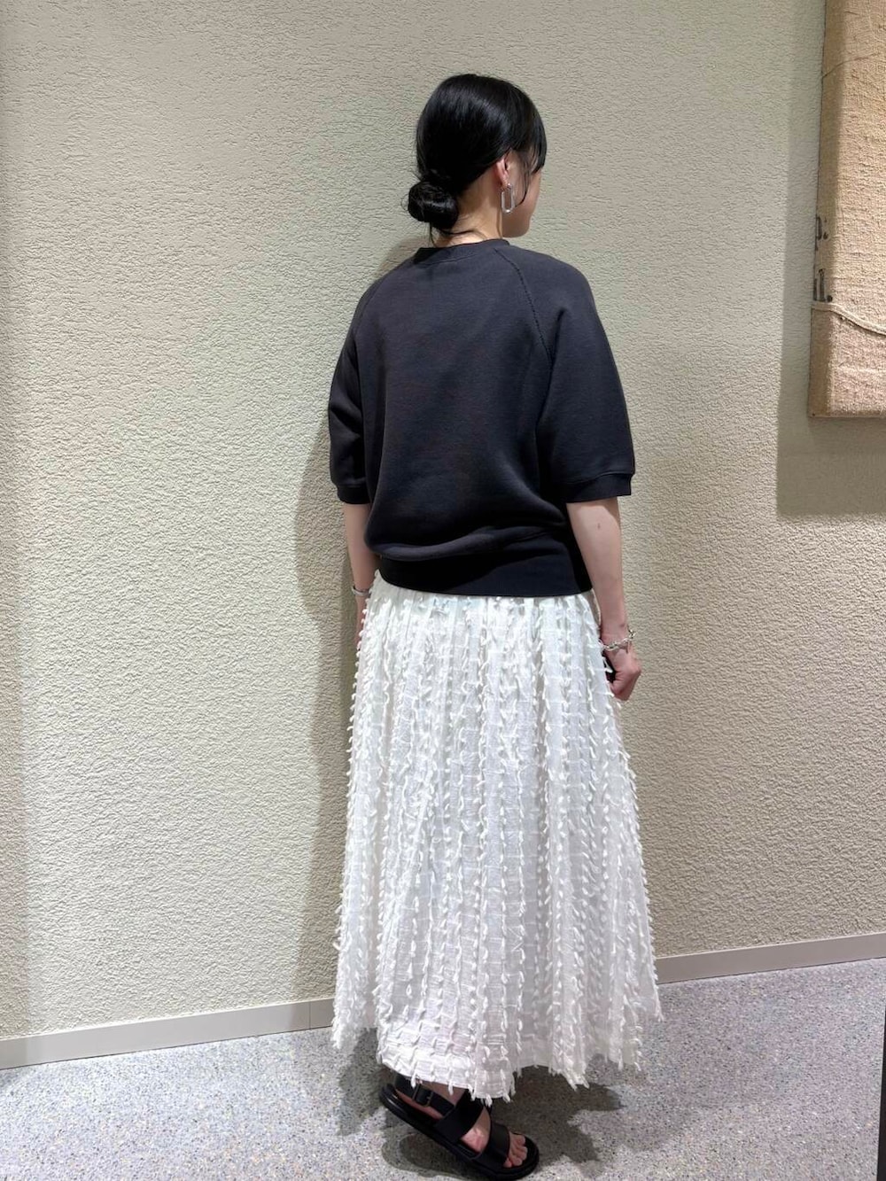 ホワイト系のスカート、グレー系のスウェットを着用したレディースの春コーディネートの3枚目の写真