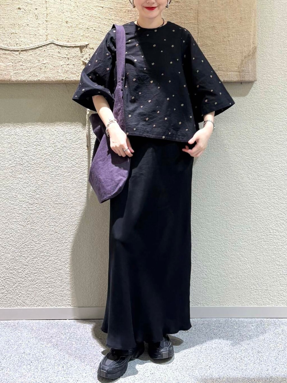 ブラック系のスカート、パープル系のトートバッグ、ブラック系のシャツ/ブラウスを着用したレディースの春コーディネートの4枚目の写真