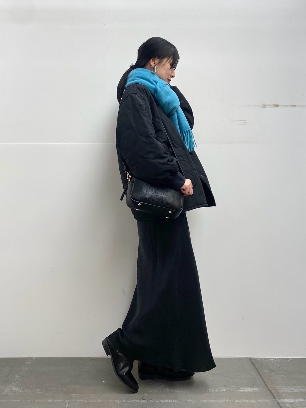 ブラック系のブルゾン、ホワイト系のTシャツ/カットソー、ブラック系のスカートを着用したレディースの秋コーディネートの2枚目の写真