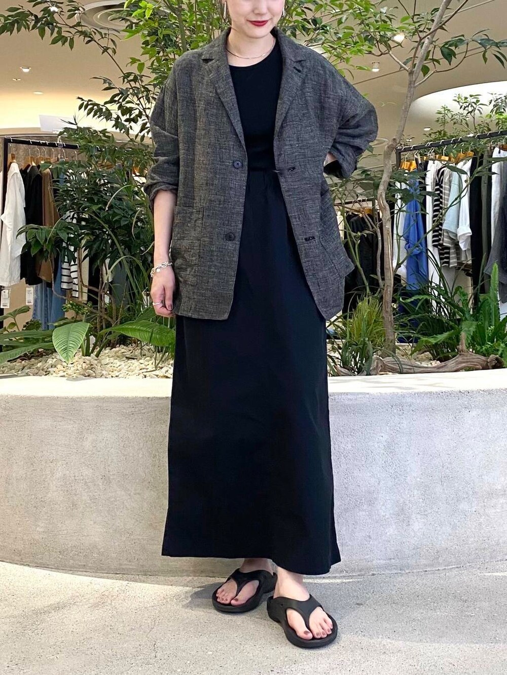 ブラック系のスカート、ブラック系のテーラードジャケット、ブラック系のタンクトップを着用したレディースの夏コーディネートの5枚目の写真