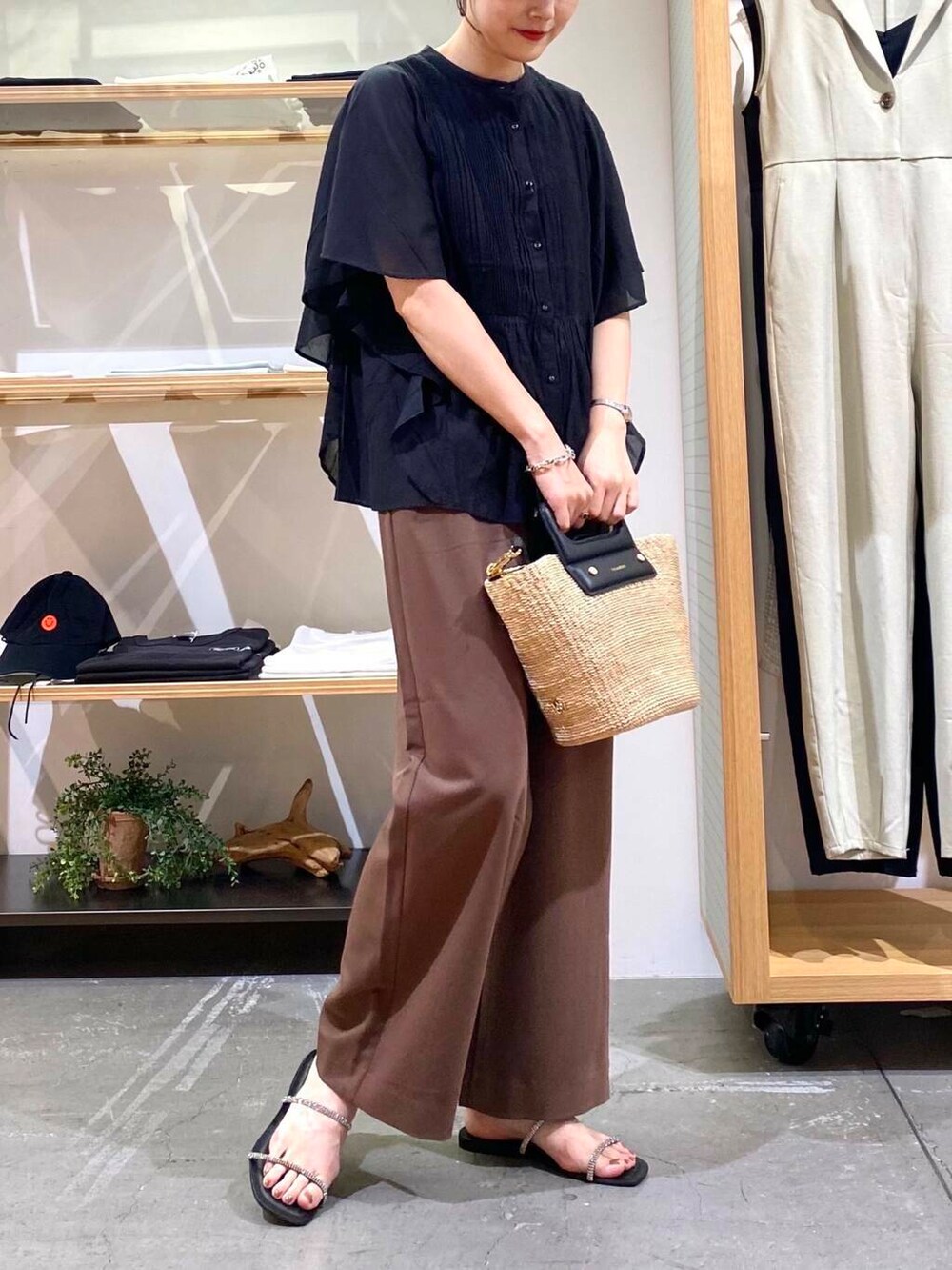 ベージュ系のハンドバッグ、ブラック系のサンダル、ブラック系のシャツ/ブラウスを着用したレディースの夏コーディネートの5枚目の写真