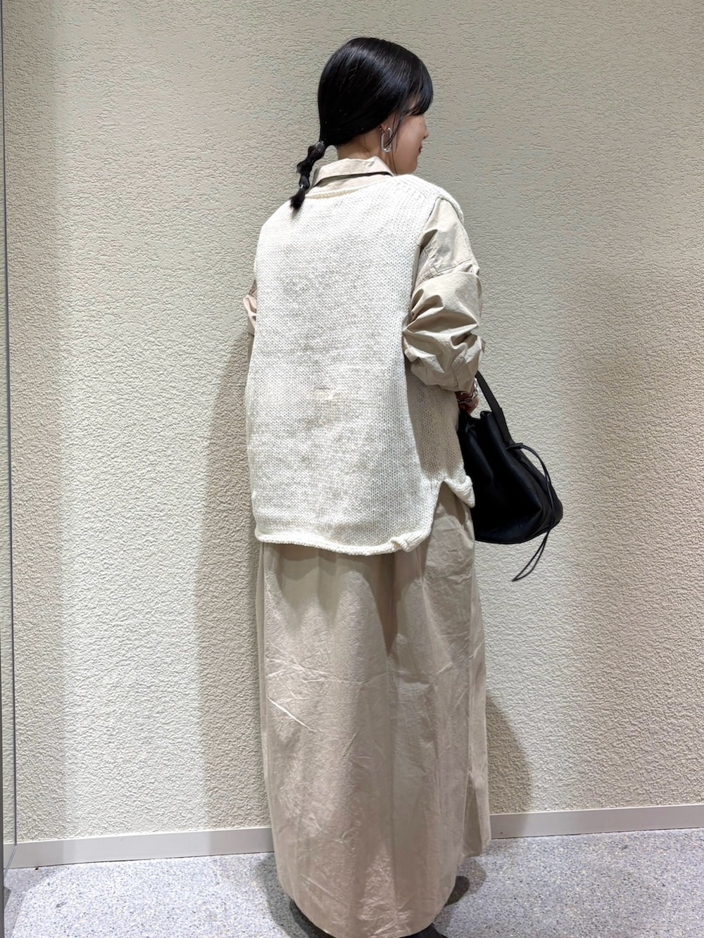 ベージュ系のワンピース、ホワイト系のニット/セーター、ブラック系のバレエシューズを着用したレディースの秋コーディネートの3枚目の写真
