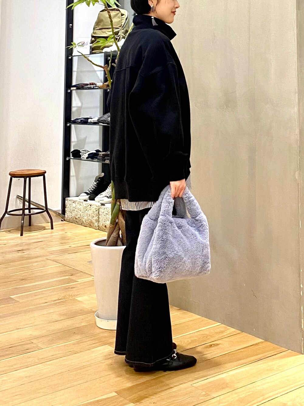 ブラック系のスウェット、ブルー系のシャツ/ブラウス、ブルー系のデニムパンツを着用したレディースの冬コーディネートの5枚目の写真