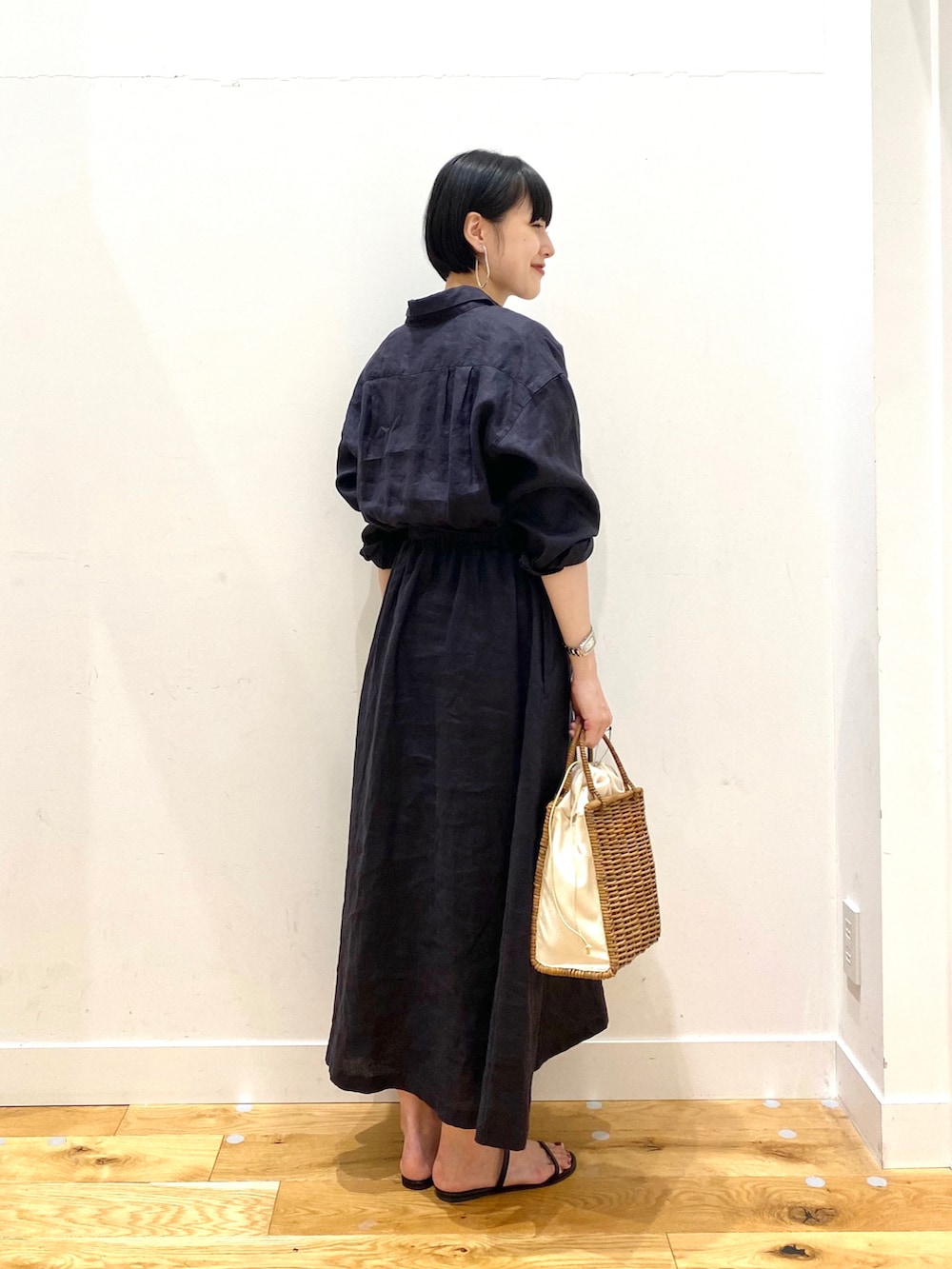 ブルー系のワンピース、ホワイト系のハンドバッグ、ブラック系のサンダルを着用したレディースの夏コーディネートの3枚目の写真