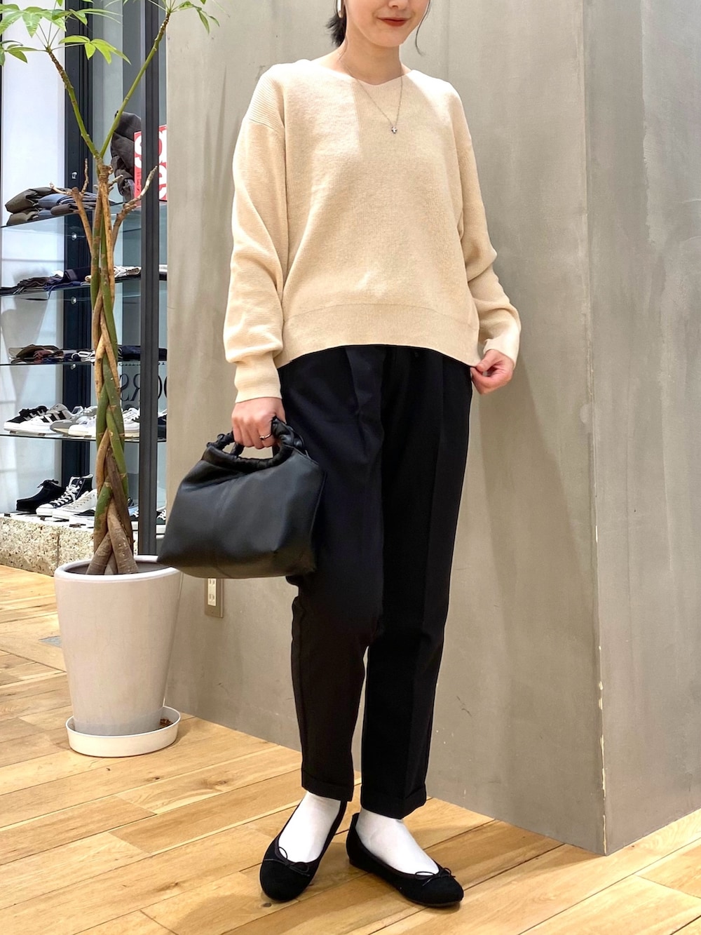 グリーン系のステンカラーコート、ホワイト系のニット/セーター、ブラック系のその他パンツを着用したレディースの冬コーディネートの7枚目の写真