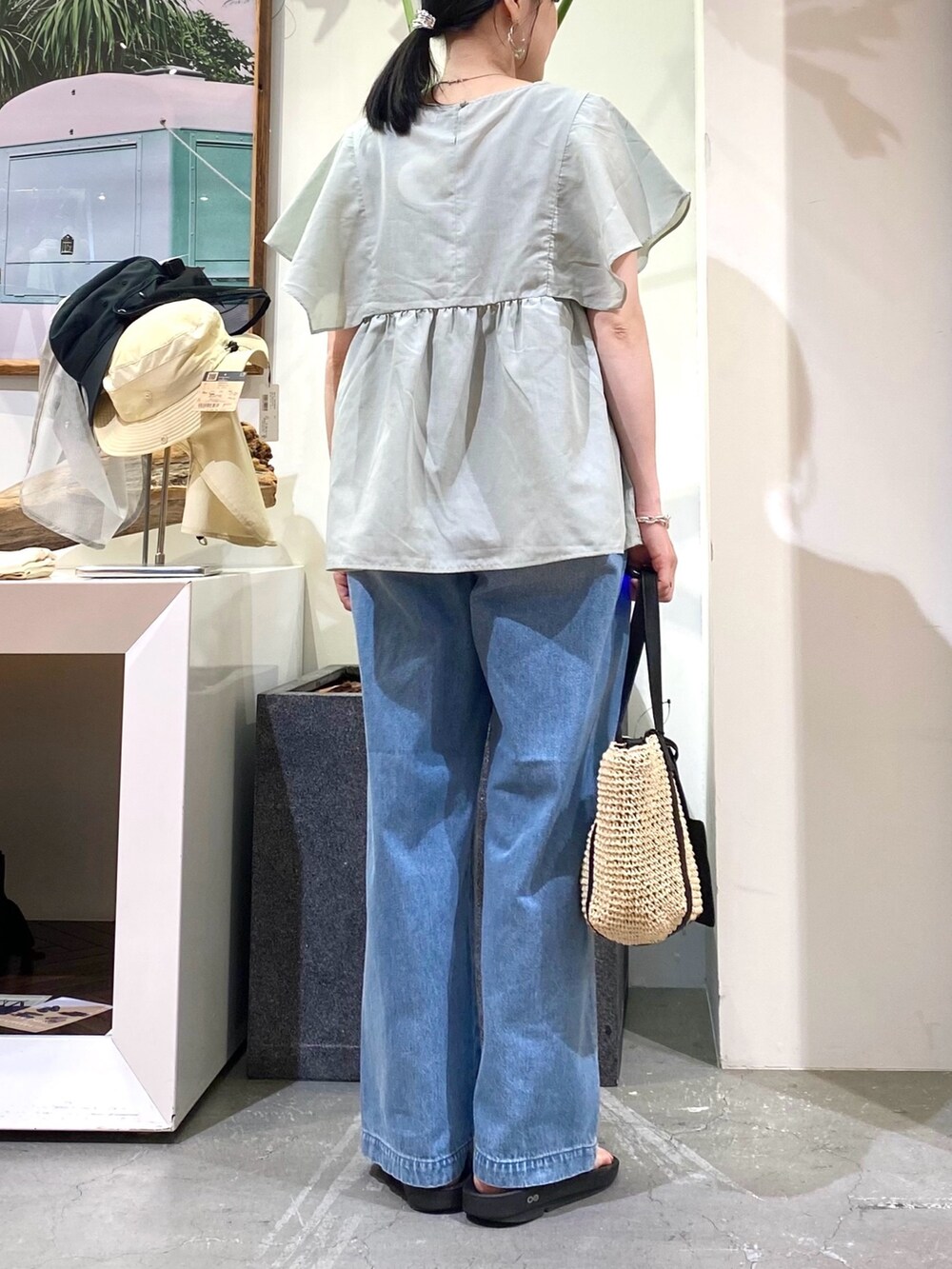 グリーン系のシャツ/ブラウス、ブルー系のデニムパンツ、ベージュ系のトートバッグを着用したレディースの夏コーディネートの5枚目の写真