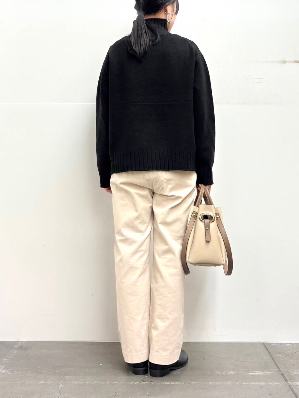 ホワイト系のトートバッグ、ブラック系のブーツ、ホワイト系のその他パンツを着用したレディースの冬コーディネートの5枚目の写真