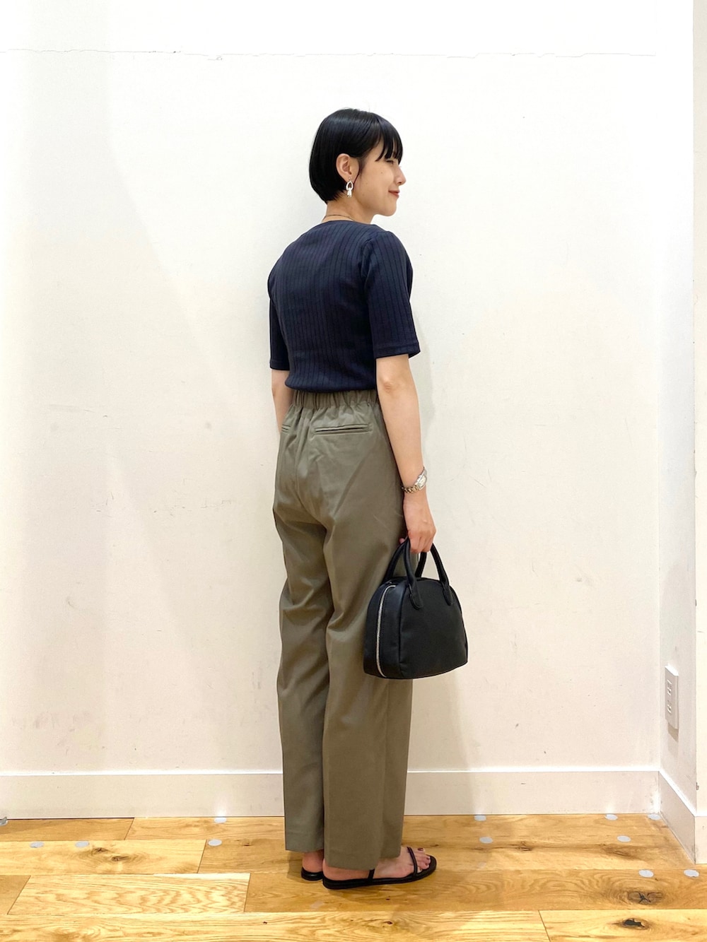 ブラック系のTシャツ/カットソー、グリーン系のその他パンツ、ブラック系のボストンバッグを着用したレディースの夏コーディネートの3枚目の写真