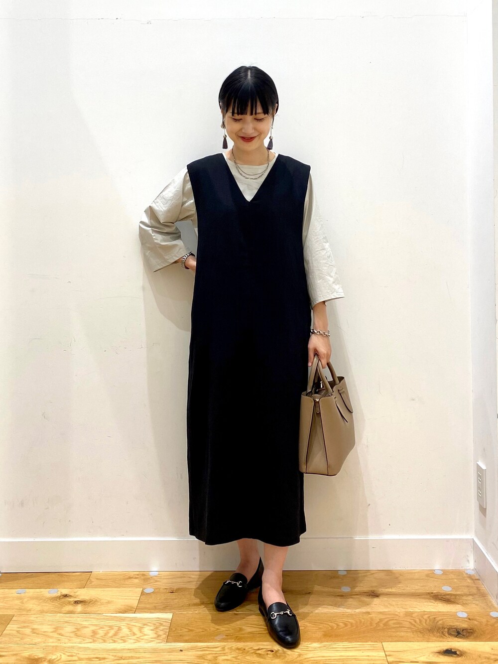 ベージュ系のシャツ/ブラウス、ブラック系のワンピース、ブラウン系のトートバッグを着用したレディースの夏コーディネートの2枚目の写真