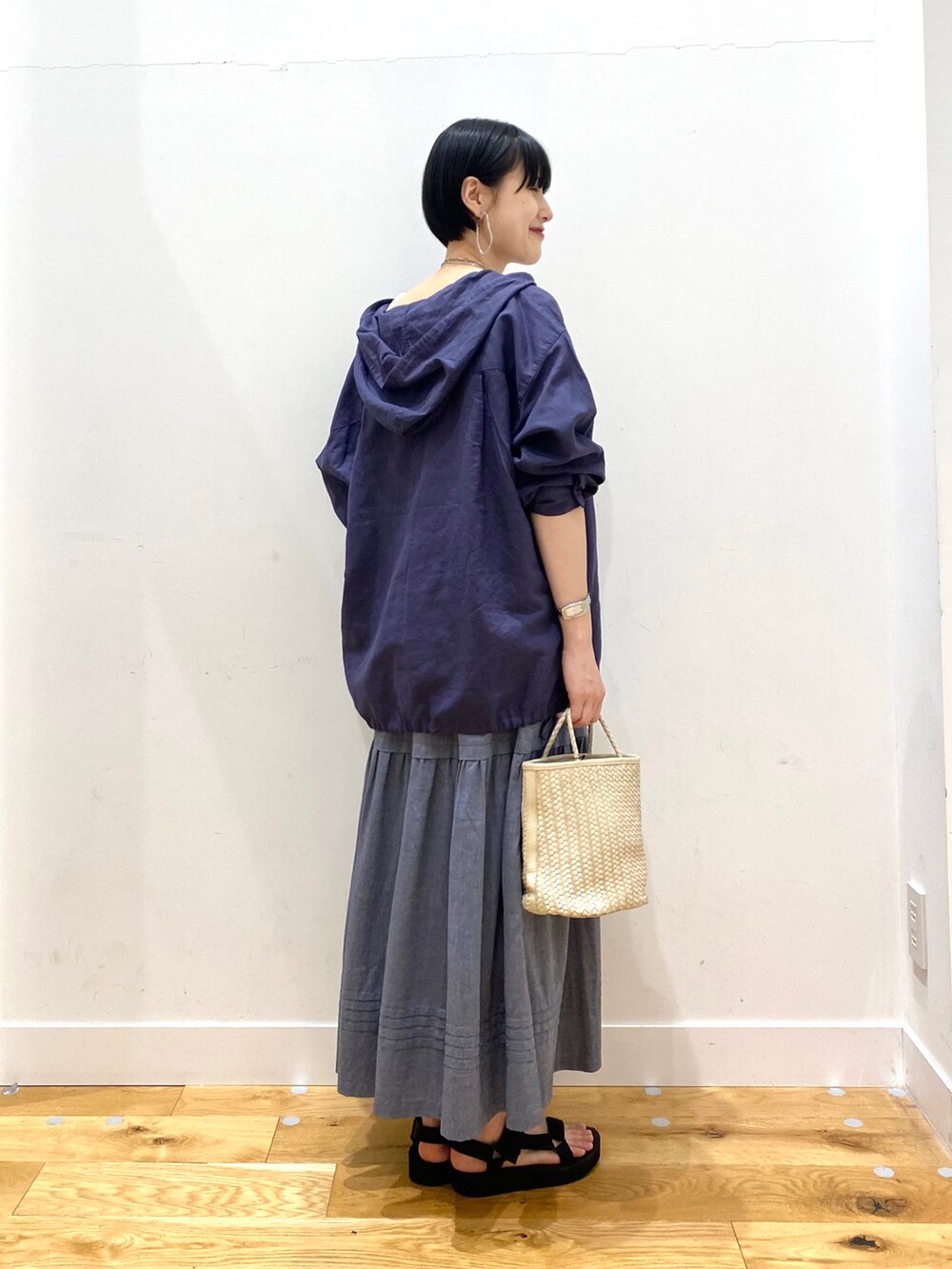 ブルー系のパーカー、ホワイト系のタンクトップ、グレー系のスカートを着用したレディースの春コーディネートの3枚目の写真