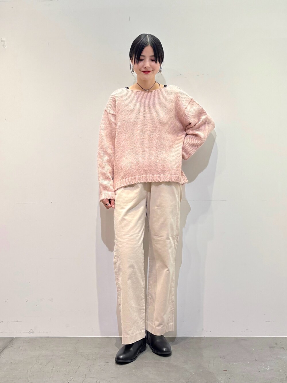ピンク系のニット/セーター、ホワイト系のその他パンツ、ブラック系のブーツを着用したレディースの冬コーディネートの3枚目の写真