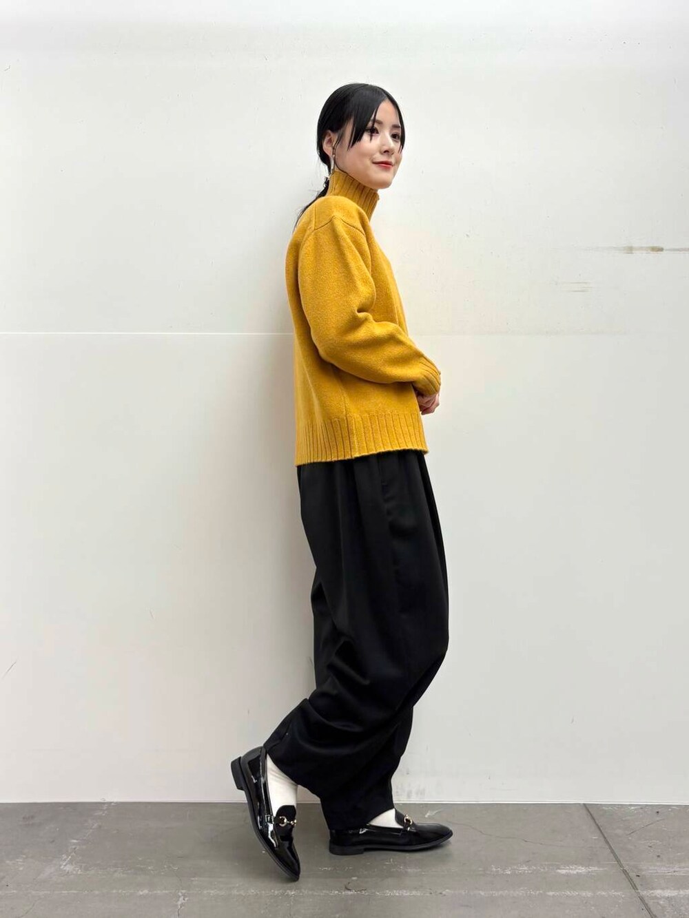 ブラック系のローファー、イエロー系のニット/セーター、ブラック系のその他パンツを着用したレディースの冬コーディネートの4枚目の写真