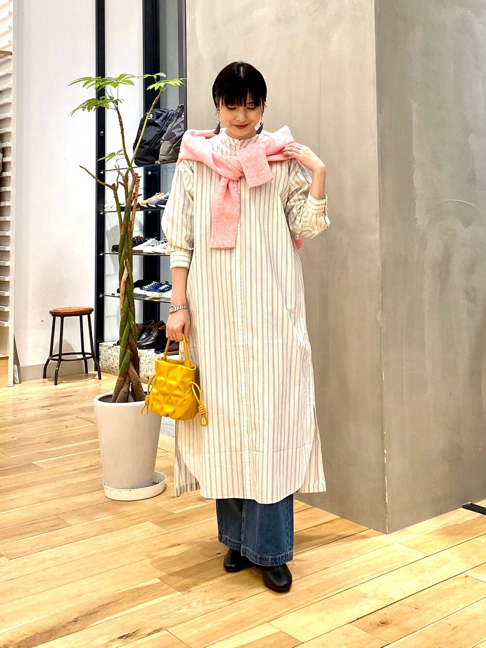 ピンク系のカーディガン/ボレロ、ブルー系のデニムパンツ、ブラック系のブーツを着用したレディースの冬コーディネートの3枚目の写真