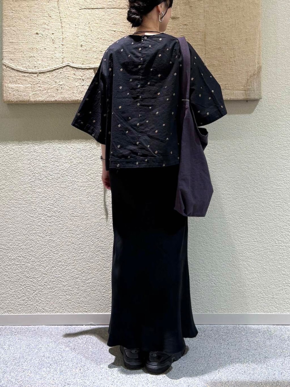 ブラック系のスカート、パープル系のトートバッグ、ブラック系のシャツ/ブラウスを着用したレディースの春コーディネートの5枚目の写真