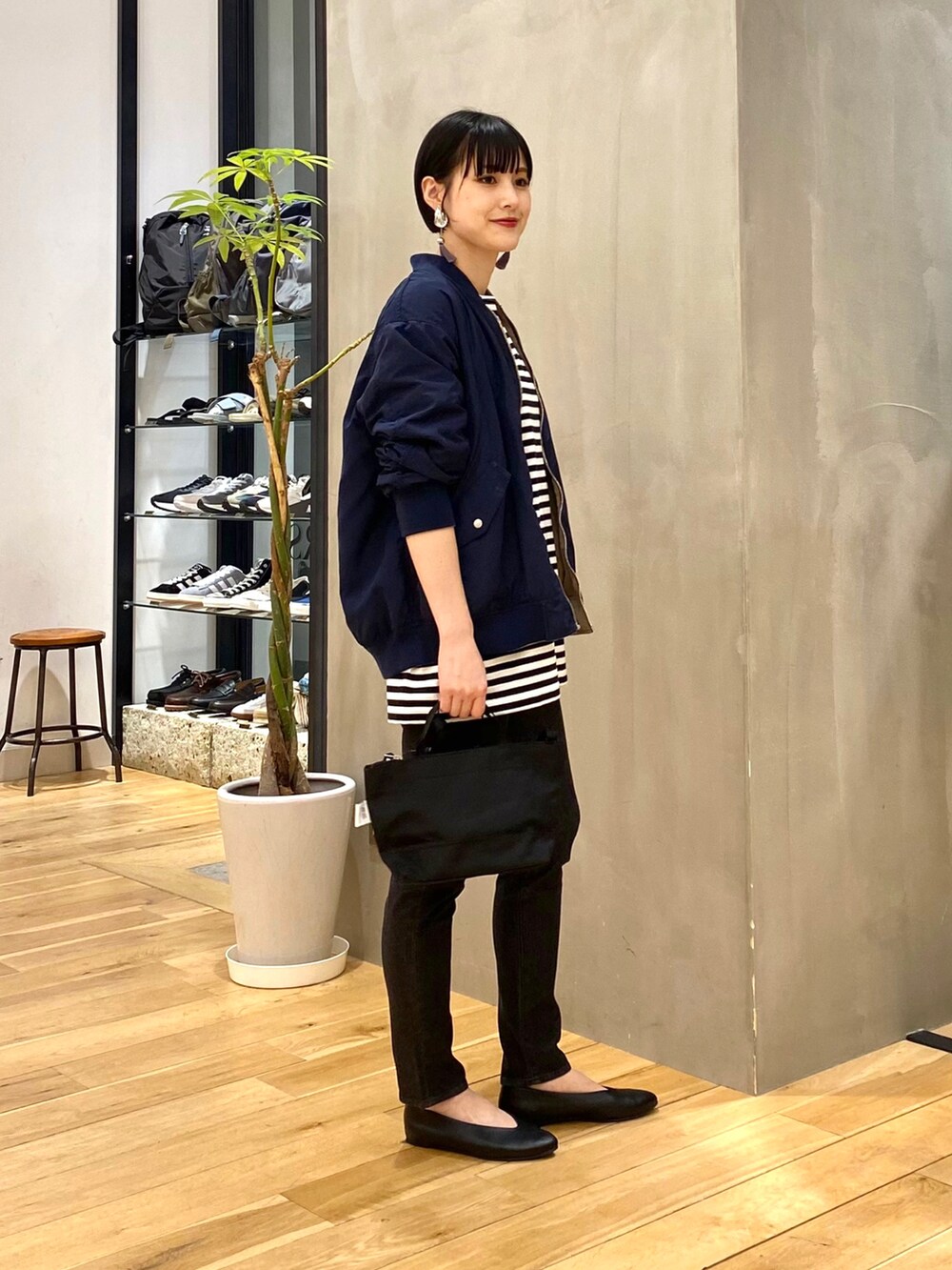 ベージュ系のMA-1、ブラック系のTシャツ/カットソー、ブラック系のデニムパンツを着用したレディースの春コーディネートの2枚目の写真
