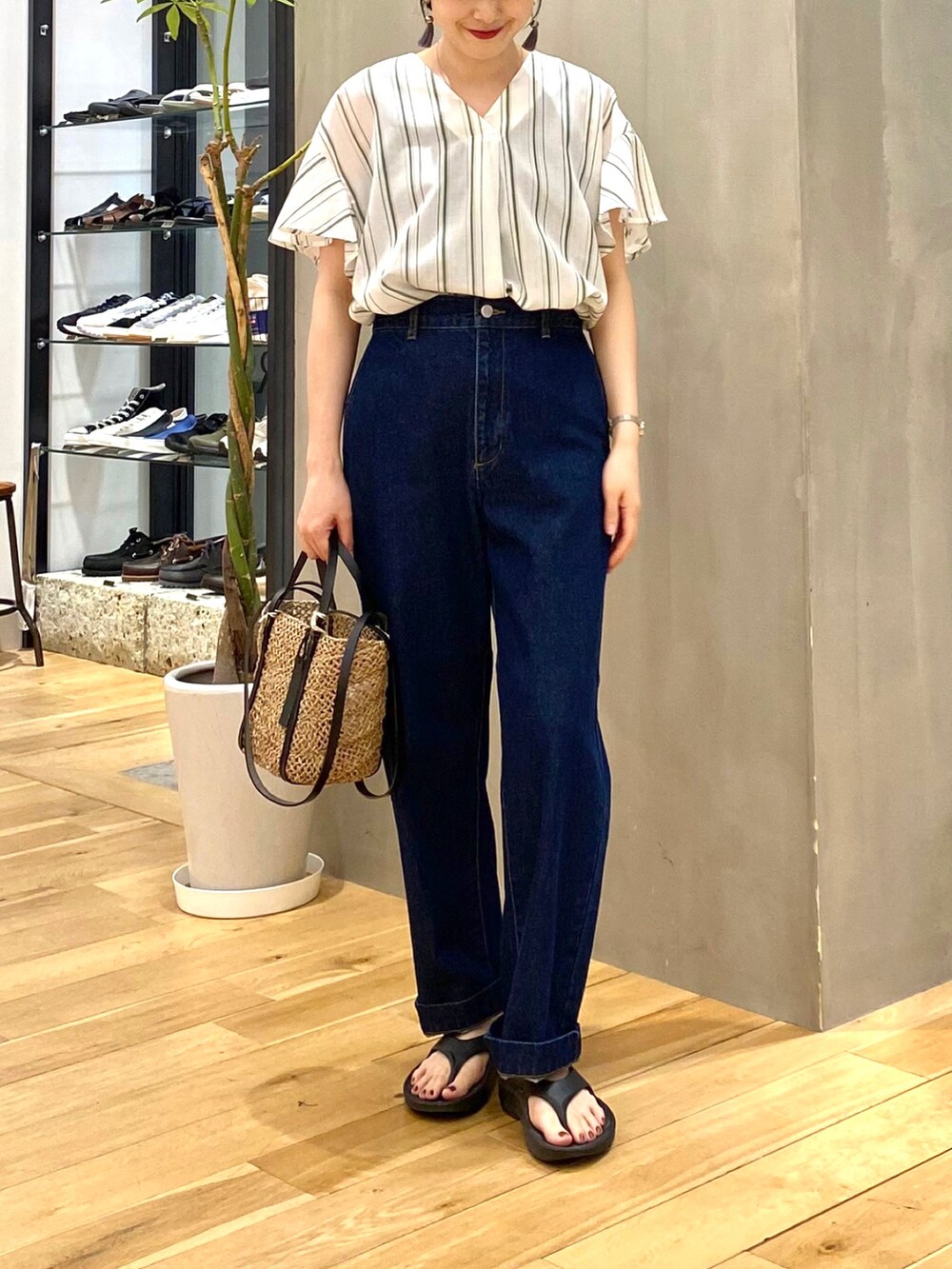 グリーン系のシャツ/ブラウス、ブルー系のデニムパンツ、ブラック系のサンダルを着用したレディースの春コーディネートの4枚目の写真
